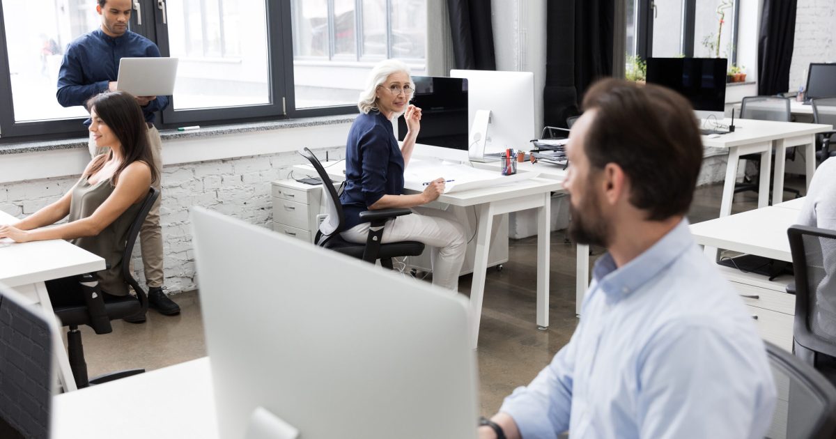 Group of business people talking to each other while working together at the office